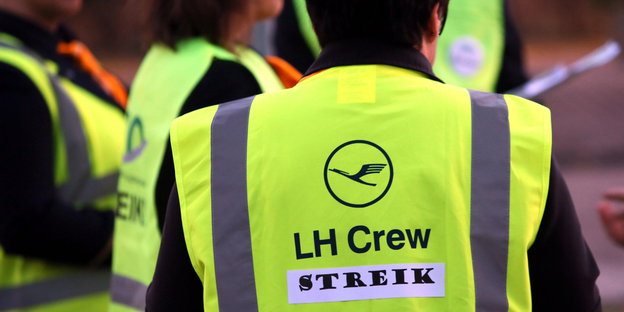 Flugbegleiter der Lufthansa in Warnwesten mit Streik-Aufkleber
