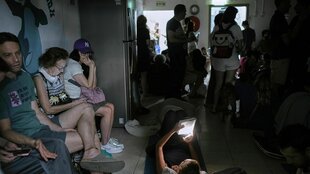 Menschen sitzen und stehen dicht gedrängt in einem Schutzraum