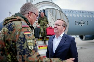 Pistorius auf einem Militärflughafen mit einem Bundeswehrsoldaten