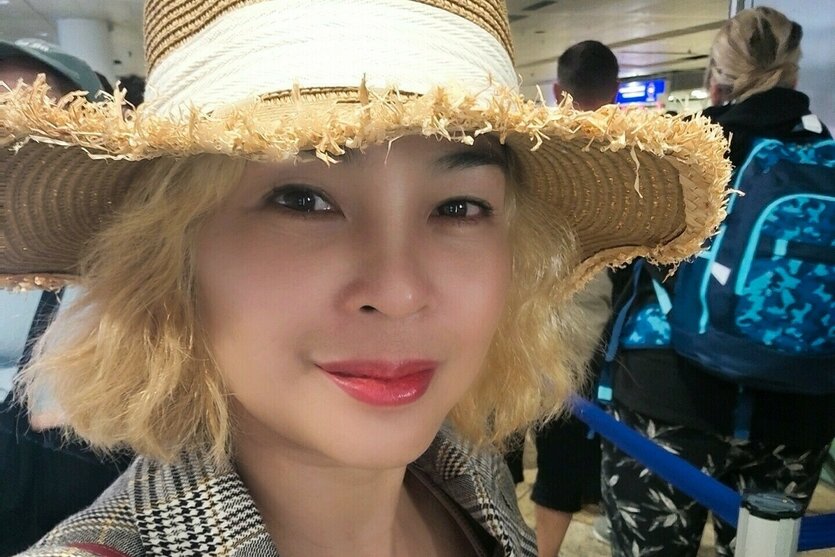 Porträt von Hue Nhu mit blonden Haaren und Sonnenhut