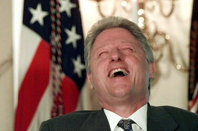 Zu sehen ist der ehemalige US-Präsident Bill Clinton, der beim Lachen den Kopf zurückwirft.