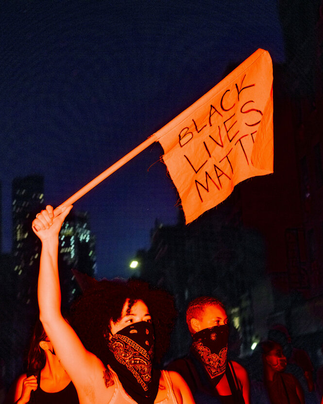 Vermummte protestieren mit Fahne.