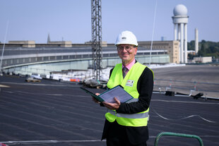 Christian Gaebler (SPD), Berliner Senator für Stadtentwicklung, Bauen und Wohnen, steht bei einer Baustellenbesichtigung der Vorfeldüberdachung am ehemaligen Flughafen Tempelhof auf dem Dach.