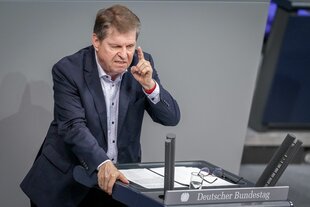 Der SPD-Politiker Ralf Stegner steht mit einem blauen Anzug und erhobenem Zeigefinger am Rednerpult des Bundestags