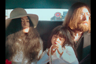 Yoko Ono, ihre Tochter Kyoko Ono Cox und John Lennon sitzen in einem Auto.