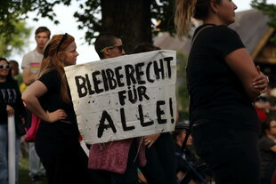 Demonstranten stehen mit einem Banner 