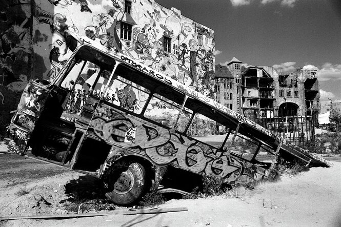 Ein ausgeschlachteter Bus steckt in der Erde hinter dem Kunsthaus Tacheles