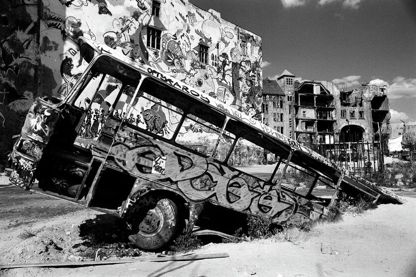 Ein ausgeschlachteter Bus steckt in der Erde hinter dem Kunsthaus Tacheles