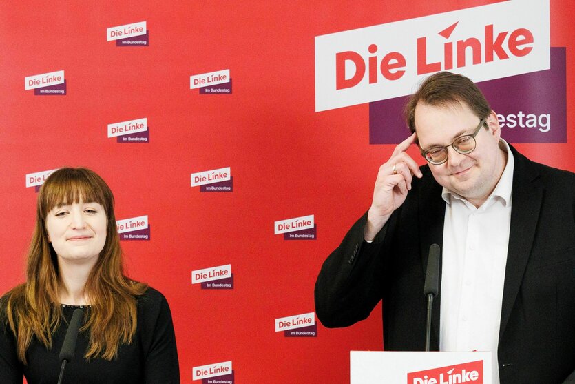Heidi Reichinnek und Sören Pellmann stehen nebeneinander vor einer Wand mit dem Logo der Linken