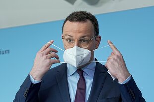 Spahn mit Masken in den Händen