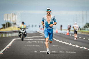 Patrick Lange läuft in Hawaii auf der Straße, im Hintergrund ein Motorrad