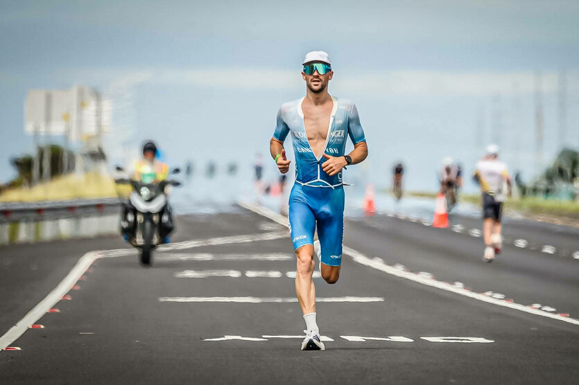 Patrick Lange läuft in Hawaii auf der Straße, im Hintergrund ein Motorrad