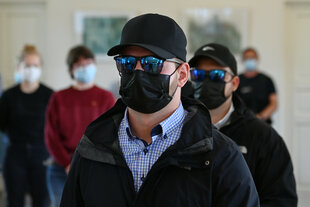 Angeklagte mit schwarzer Maske und schwarzer Cap vor Gericht