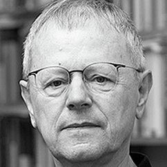 ein schwarz-Weiß Portrait eines Mannes mit Brille und dunklem Oberteil