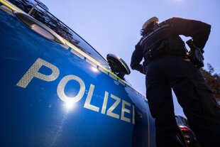 Polizist vor Einsatzwagen