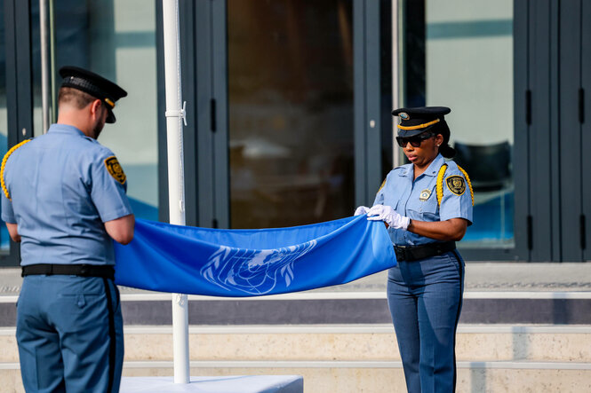 Eine Flagge der Vereinten Nationen wird von zwei Personen gehalten