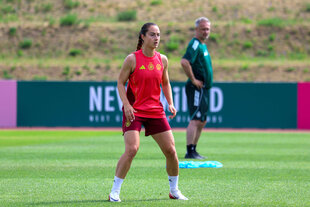 Däbritz beim Training, im Hintergrund beobachtet sie Bundestrainer Wück
