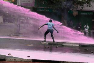 Ein Demonstrant wird von einem Wasserwerfer beschossen