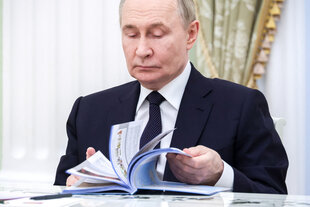 Wladimir Putin blättert in einem Schulbuch