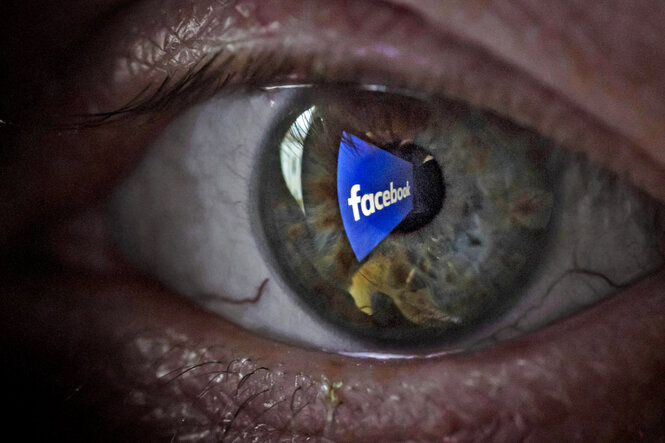 Das Logo von Facebook spiegelt sich in einem Auge