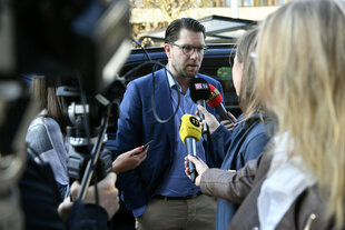 Ein Mann spricht mit Vertretern der Presse