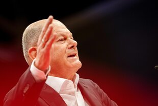 Olaf Scholz hebt die rechte Hand