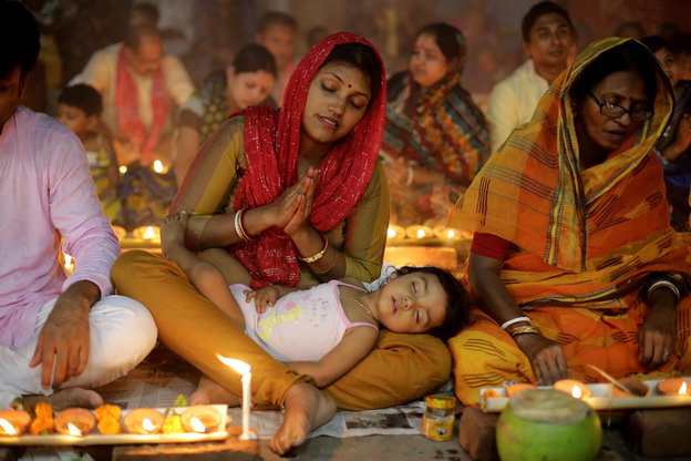 Ein Kind schläft im Schoß einer Frau, die betet