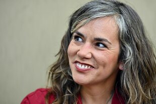 Ein Foto Einer Frau im Portrait. Sie lächelt und hat langes Haar
