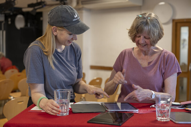 Zwei Personen hantieren an einem Tablet