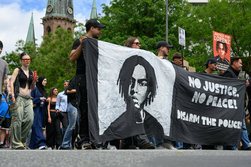 Eine Demonstration zieht am Sonntag, 30. 6. durch Oldenburgs City: ein Transparent zeigt das Bild des erschossenen Lorenz A. und fordert "Disarm the Police", entwaffnet die Polizei