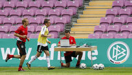 Jürgen Klinsmann und Philipp Lahm auf dem Trainingsplatz, im Hintergrund ein Mann am Laptop