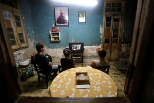 Drei junge Menschen sitzen vor einem Fernseher