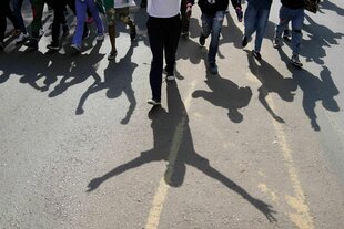 Demonstranten heben ihre Hände, als die Polizei während einer Demonstration in der Innenstadt von Nairobi Tränengas auf sie abfeuert