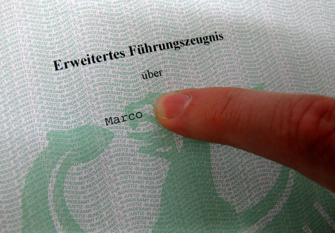 Ein Finger zeigt auf einen Ausschnitt aus einem Führungszeugnis