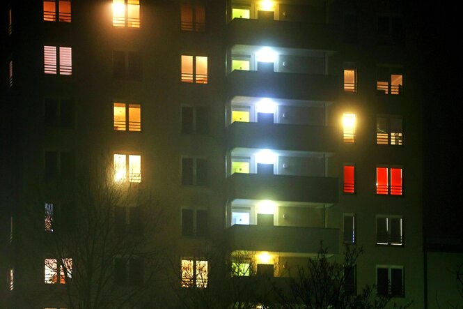 Ein Hochhaus in der Nacht, die Fenster sind erleuchtet