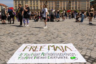 Ein Banner "Free Maja" liegt vor einer Kundgebung in Dresden