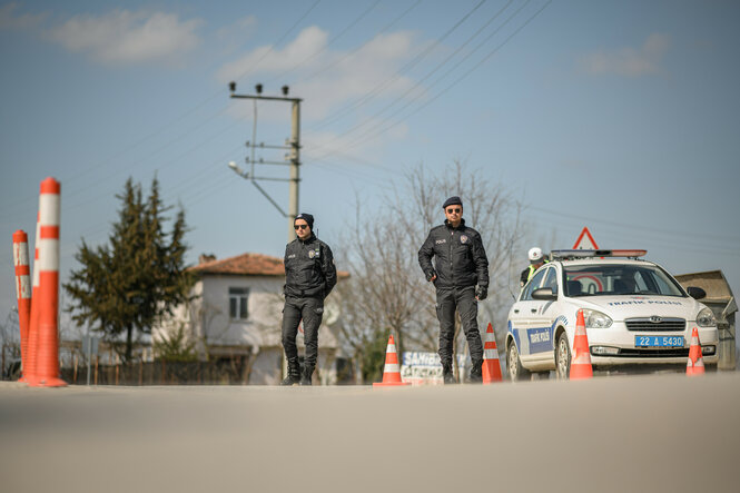 Türkische Polizisten stehen an einer Absperrzaun in der Nähe des Grenzübergangs Pazarkule-Kastanies.