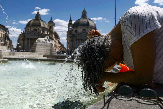 Eine Person steckt ihren Kopf in das Wasser eines Brunnens