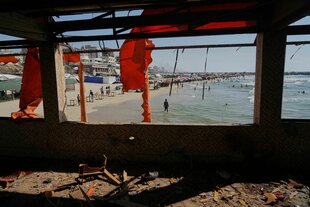 Blick aus einem zerstörten Cafe auf einen Strand mit Badenden
