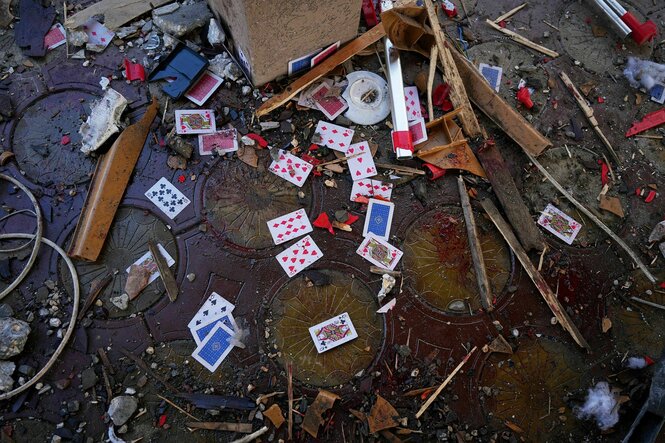 Spielkarten liegen auf einem mit Blut verschmierten Boden