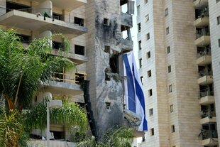 Ein teils zerstörtes Haus mit Israelflagge