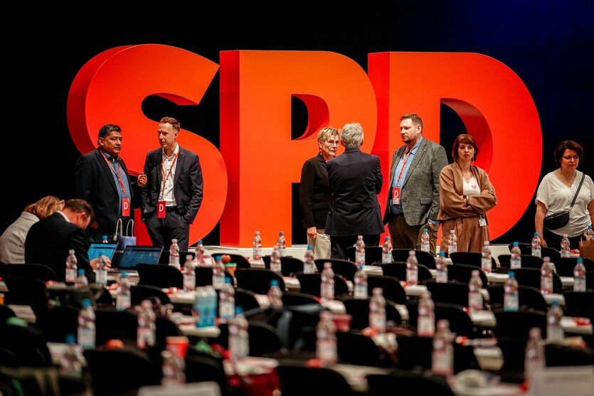 Delegierte stehen vor einem großen SPD Logo auf dem Bundesparteitag