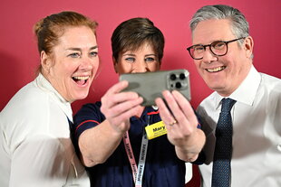 Keir Starmer lacht zusammen mit zwei Frauen in eine Smartphonekamera