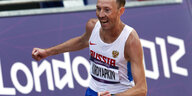 Sportler läuft vor einem Werbebanner mit der Aufschrift „London 2012“
