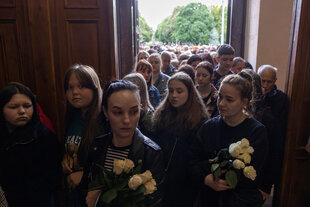 Menschenschlange auf der Beerdigung bei einem Luftangriff auf die Ukraine getöteter Kinder