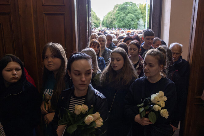 Menschenschlange bei einer Beerdigung um getötete Kinder bei Luftangriff auf die Ukraine