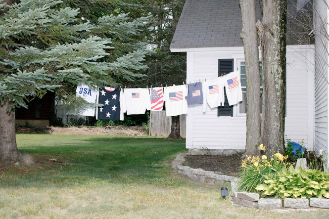 An einer Wäscheleine hängt Kleidung mit Amerika-Flagge
