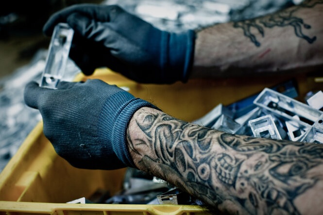 Hände mit Handschuhen arbeiten mit Metallteilen