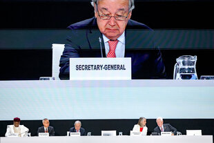 UN-Generalsekretär Antioni Guterres ist auf einem Bildschirm zu sehen, wie er bei der Bekanntgabe der Tagesordnung vom Podium aus spricht