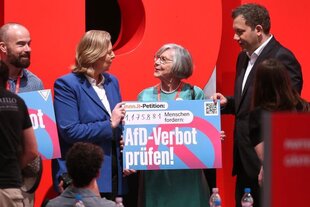SPD-Mitglieder auf der Bühne des Parteitages vor einem riesigen SPD-Logo.